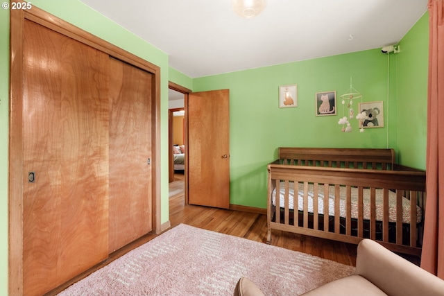 bedroom featuring wood finished floors, a closet, and baseboards
