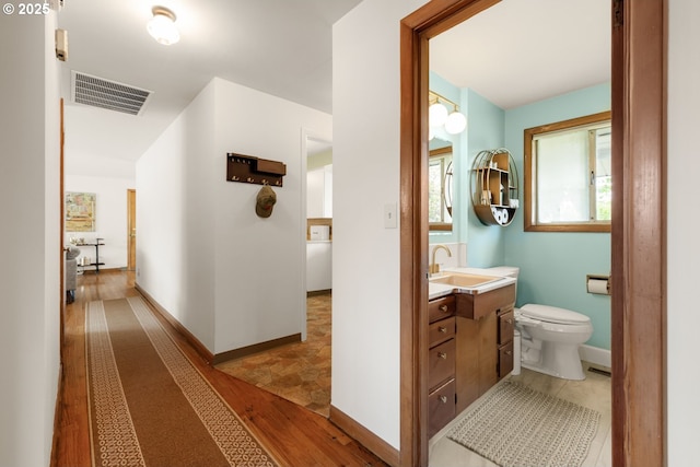 hallway featuring a sink and baseboards