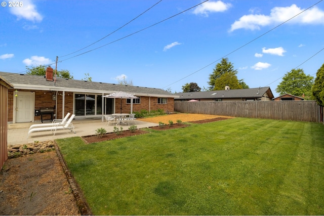 rear view of property featuring a patio, brick siding, and a chimney