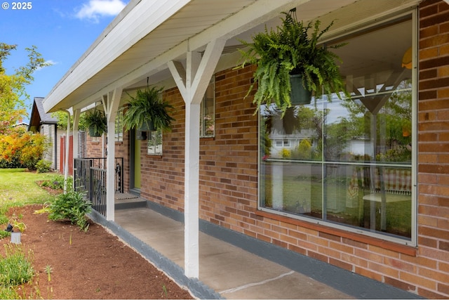 entrance to property with brick siding and a porch