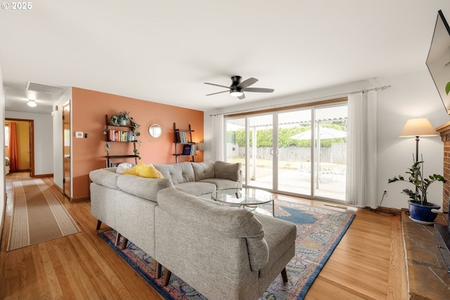 living area featuring a ceiling fan, wood finished floors, and baseboards