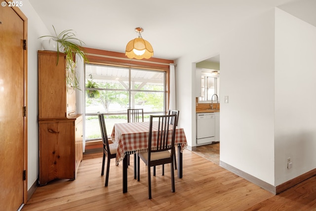 dining room featuring light wood-style flooring and baseboards