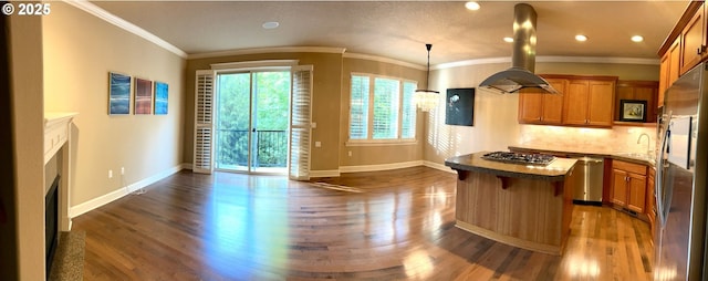 2107 NW Village Cir, Portland, OR 97229 - kitchen featuring stainless steel appliances, dark wood finished floors, baseboards, a kitchen island, and crown molding