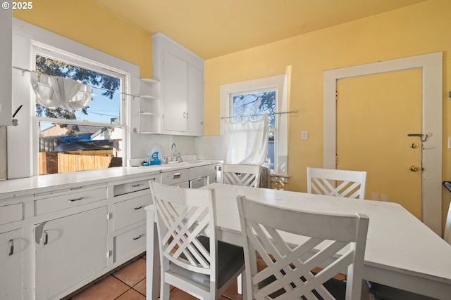 kitchen featuring a healthy amount of sunlight, light tile patterned floors, and white cabinets