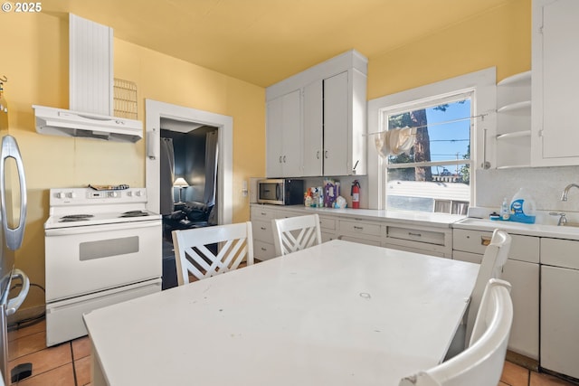 kitchen with light tile patterned flooring, white cabinetry, electric stove, decorative backsplash, and exhaust hood