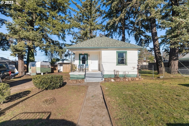 bungalow-style home with a shed, covered porch, and a front yard