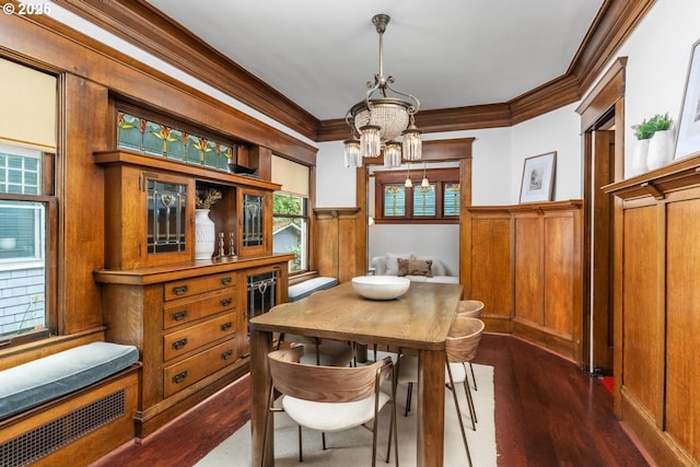 2517 NE 21st Ave, Portland, OR 97212 - dining space with a chandelier, a wainscoted wall, ornamental molding, dark wood-type flooring, and a decorative wall
