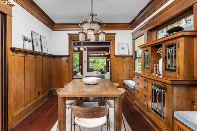 2517 NE 21st Ave, Portland, OR 97212 - dining area featuring crown molding, wainscoting, dark wood-style flooring, a chandelier, and wooden walls
