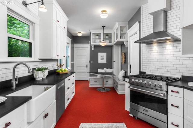2517 NE 21st Ave, Portland, OR 97212 - kitchen featuring wall chimney range hood, stainless steel appliances, dark countertops, backsplash, and white cabinets