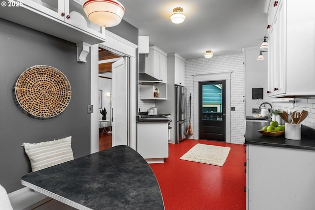 2517 NE 21st Ave, Portland, OR 97212 - kitchen with freestanding refrigerator, dark countertops, wall chimney range hood, white cabinets, and backsplash