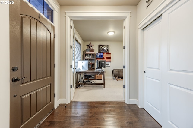 foyer entrance featuring baseboards and dark wood finished floors