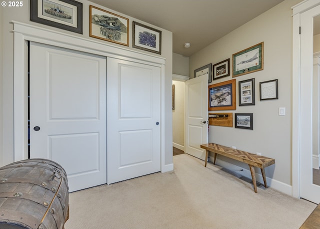 living area with baseboards and light colored carpet