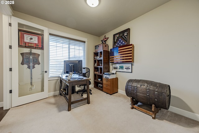 office space featuring light carpet and baseboards