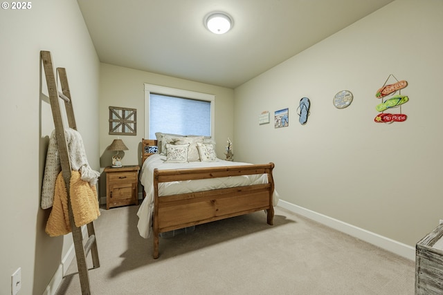 bedroom with baseboards and light colored carpet