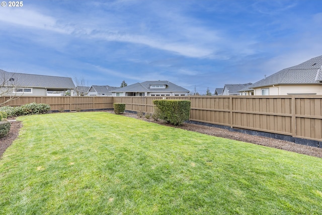 view of yard with a fenced backyard and a residential view