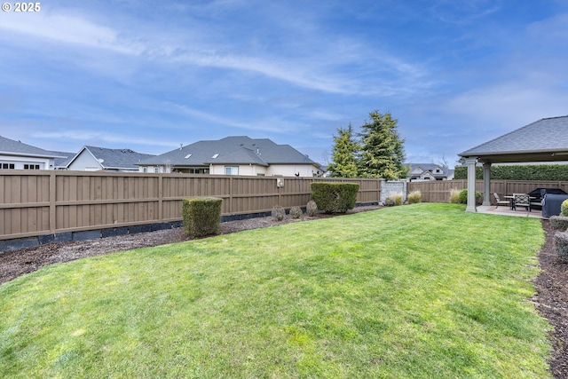 view of yard featuring a patio area, a fenced backyard, and a residential view