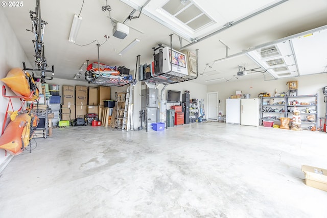 garage with a garage door opener and freestanding refrigerator