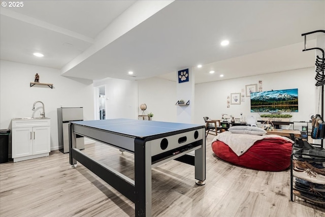 game room featuring sink and light wood-type flooring