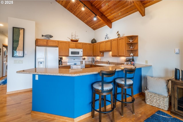 1323 Village Loop, Bandon, OR 97411 - kitchen featuring white appliances, a wood ceiling with exposed beams, light wood-style floors, stacked washer / drying machine, and a peninsula