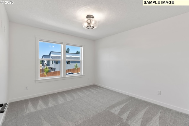 carpeted spare room featuring a textured ceiling and baseboards