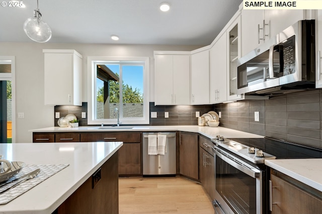kitchen featuring light countertops, a wealth of natural light, appliances with stainless steel finishes, and a sink