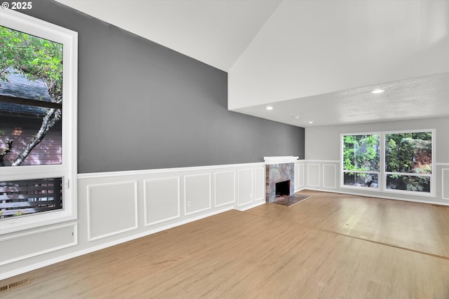 19915 SW Celebrity St, Beaverton, OR 97078 - unfurnished living room with a fireplace, plenty of natural light, a decorative wall, and wood finished floors