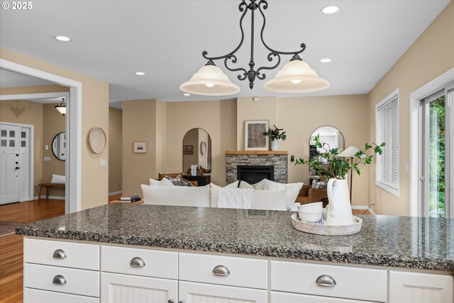 2053 Lakeview Dr, Eugene, OR 97408 - kitchen with wood finished floors, white cabinets, a fireplace, pendant lighting, and recessed lighting
