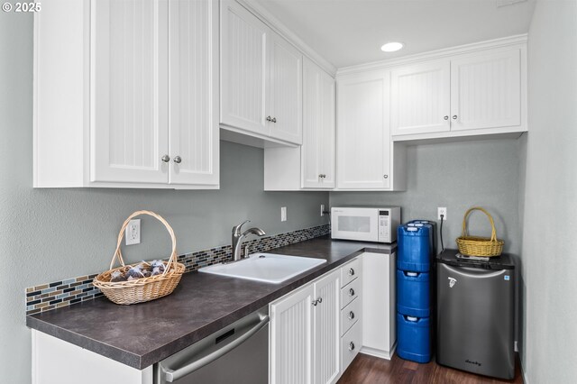 2053 Lakeview Dr, Eugene, OR 97408 - kitchen featuring stainless steel dishwasher, white microwave, dark countertops, white cabinetry, and recessed lighting