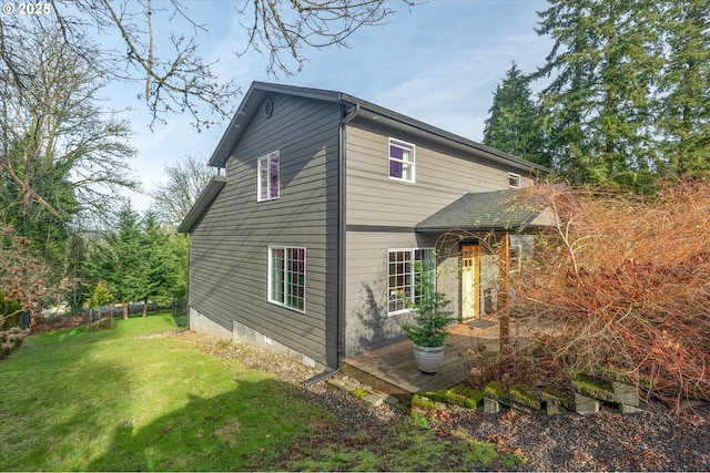 view of side of home featuring crawl space and a yard