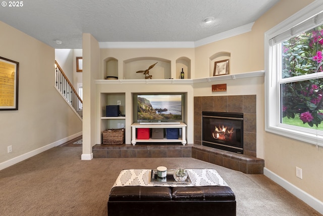 1613 SW Hume Ct, Portland, OR 97219 - carpeted living area with baseboards, built in features, a tile fireplace, a textured ceiling, and stairs