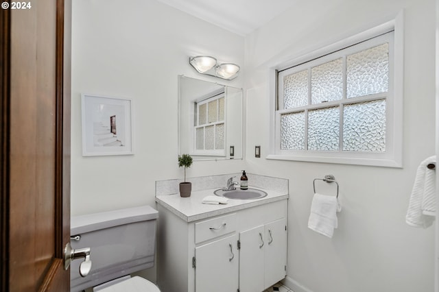 bathroom with toilet, vanity, and baseboards