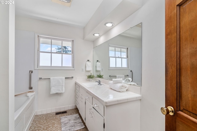bathroom with vanity, baseboards, recessed lighting, and a tub