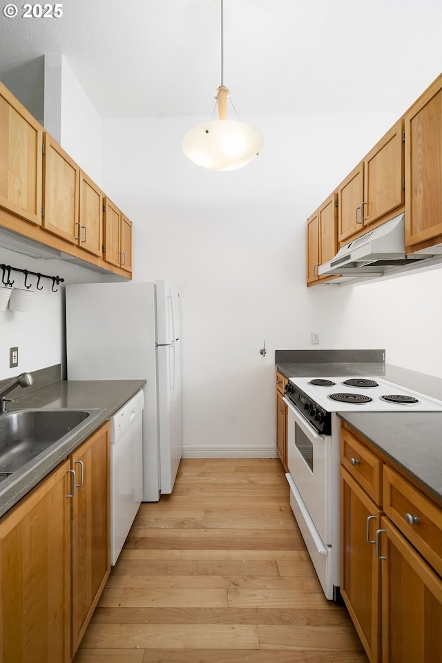 1910 SW 18th Ave Unit 34, Portland, OR 97201 - kitchen with white appliances, light wood-style flooring, dark countertops, under cabinet range hood, and decorative light fixtures