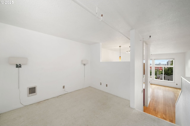 1910 SW 18th Ave Unit 34, Portland, OR 97201 - spare room with heating unit, a textured ceiling, and carpet