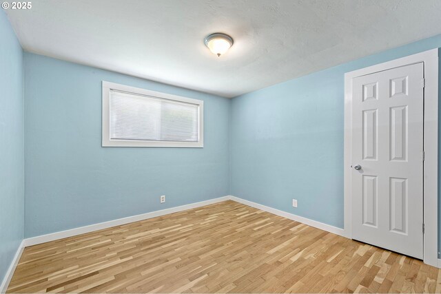 empty room featuring light wood-style floors and baseboards