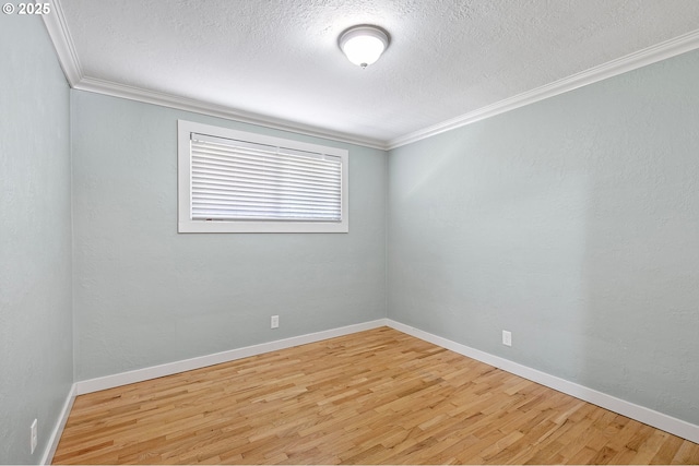 unfurnished room featuring wood finished floors, ornamental molding, a textured ceiling, and baseboards