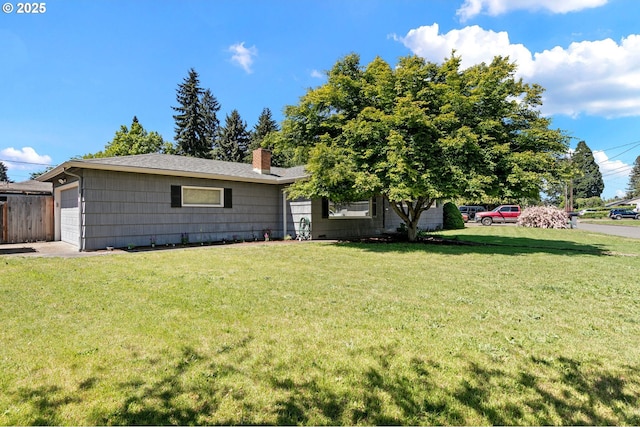 view of front of home featuring a front lawn, a chimney, and a garage