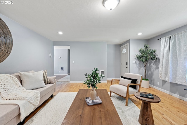 living area with recessed lighting, light wood-style flooring, and baseboards