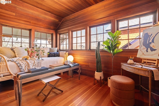 sitting room featuring wood walls, wooden ceiling, lofted ceiling, and wood finished floors