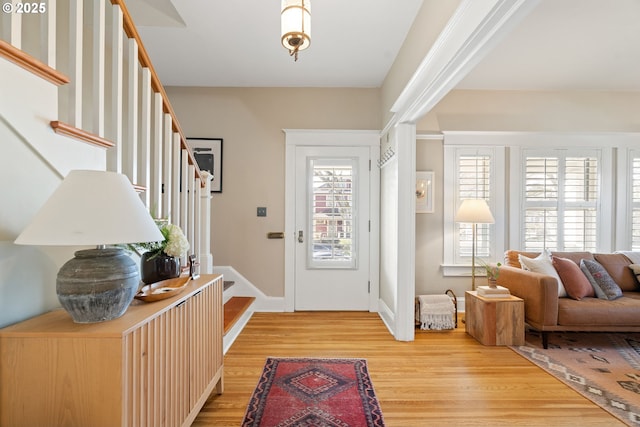 foyer with stairs and light wood-style floors