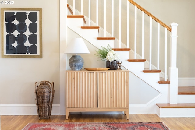 stairway with wood finished floors and baseboards