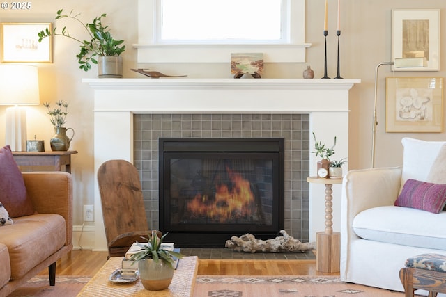 details featuring a tile fireplace and wood finished floors