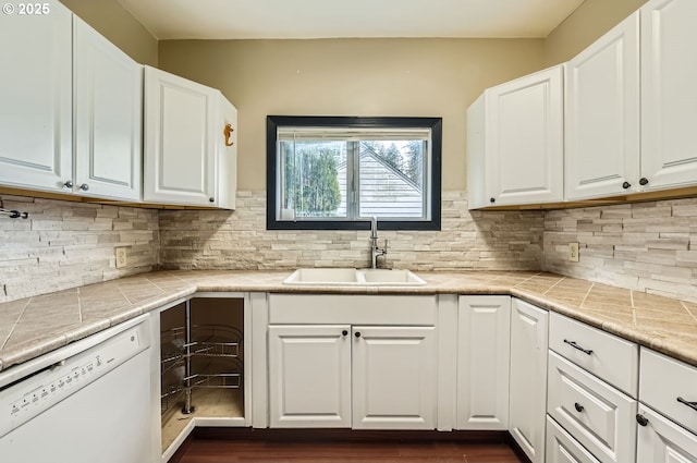 kitchen with white dishwasher, sink, and white cabinets