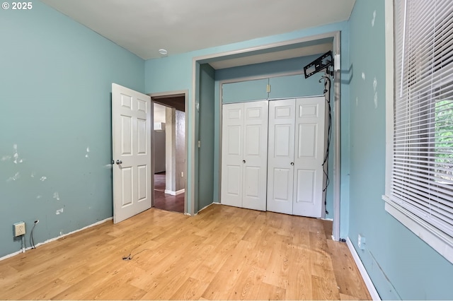 unfurnished bedroom with a closet and light hardwood / wood-style flooring