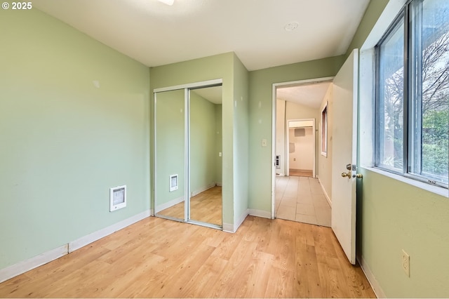 unfurnished bedroom featuring a closet and light hardwood / wood-style flooring