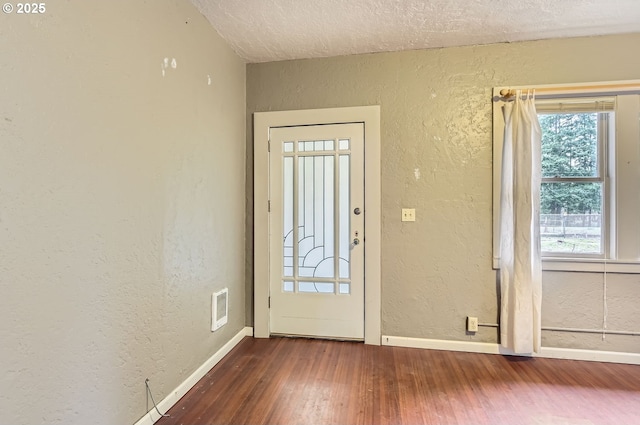 foyer with a textured ceiling and dark hardwood / wood-style flooring