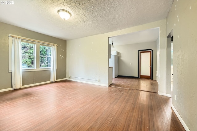 spare room with wood-type flooring and a textured ceiling