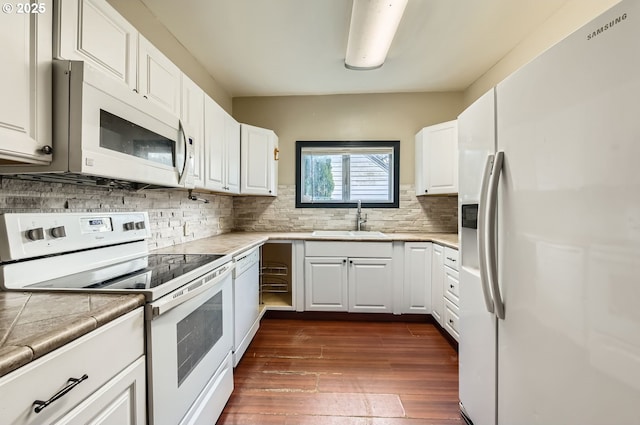 kitchen with white cabinetry, white appliances, dark hardwood / wood-style floors, and sink