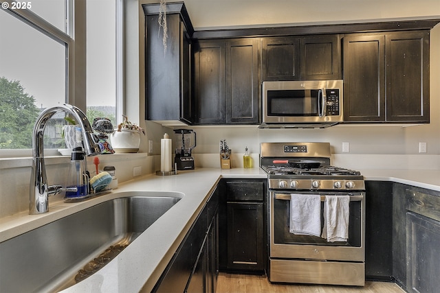 475 NE Liberty Ave, Gresham, OR 97030 - kitchen with appliances with stainless steel finishes, light wood-style floors, and dark brown cabinets
