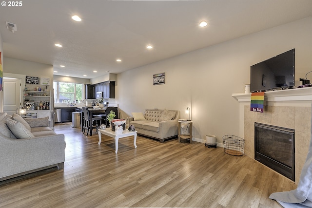 475 NE Liberty Ave, Gresham, OR 97030 - living room featuring a tile fireplace, light wood-style flooring, and recessed lighting